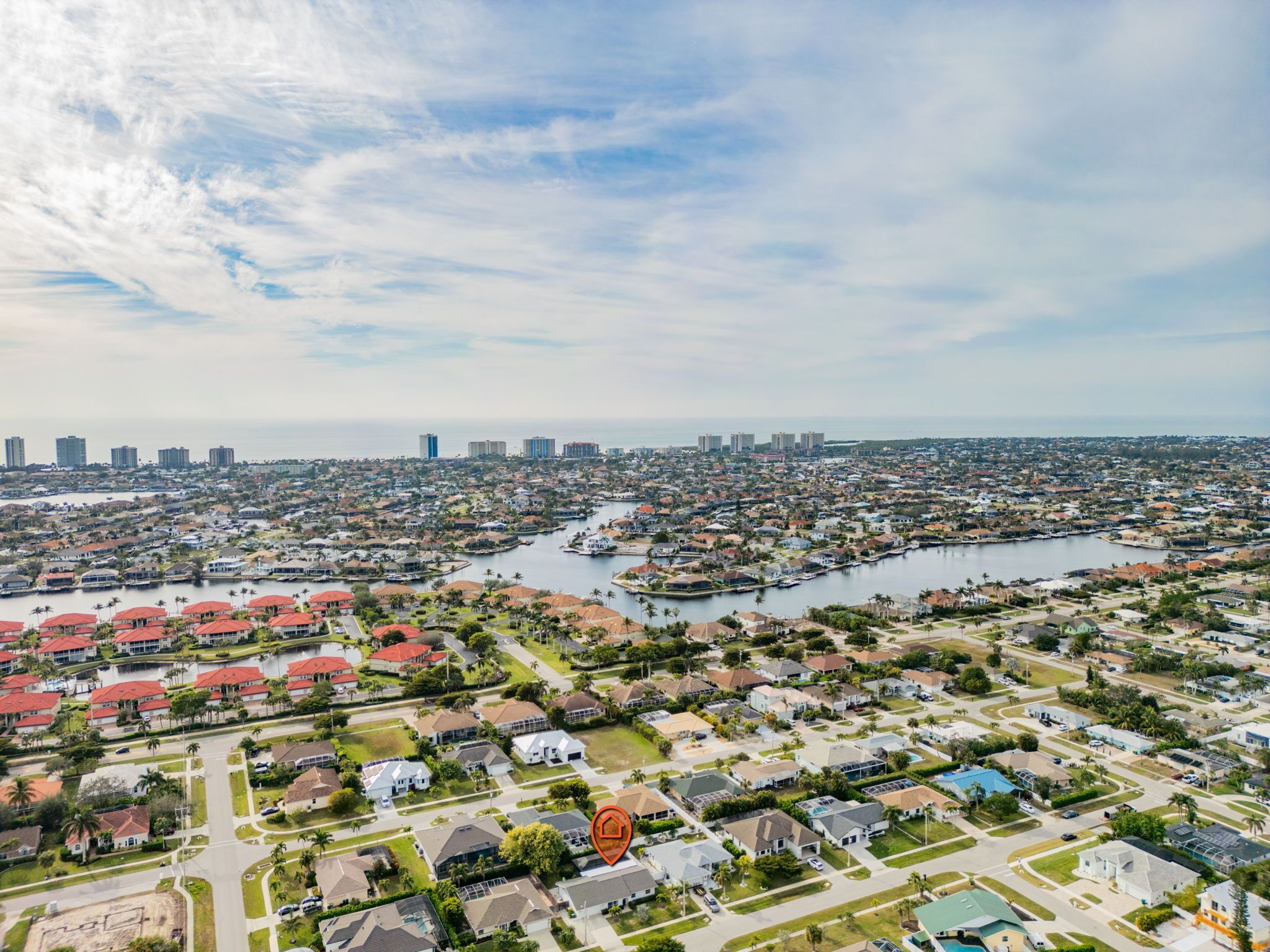 A residential area with houses, a marina, and a city skyline in the background.