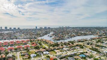 A residential area with houses, a marina, and a city skyline in the background.
