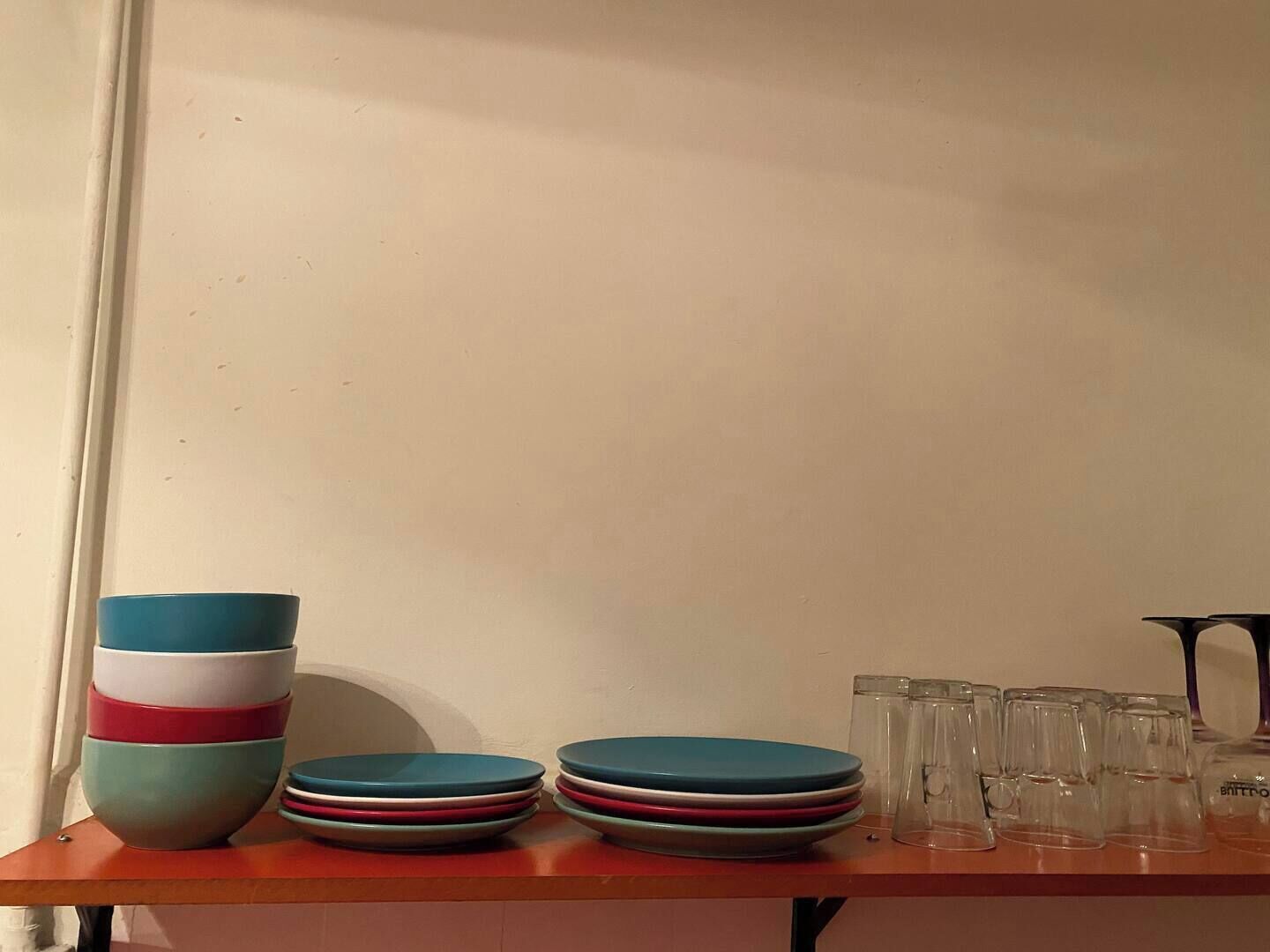 Una mesa con cuencos y vasos apilados.