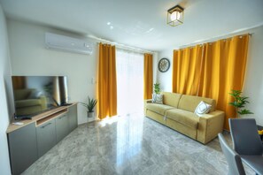 A modern living room with a sofa, TV, and a plant. - Luxury penthouse with jacuzzi, sun terrace APIC1-2 (Msida)