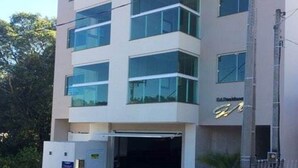 Ένα σύγχρονο κτίριο με γυάλινη πρόσοψη, μια ευδιάκριτη είσοδο και μια πινακίδα που υποδεικνύει ότι χρησιμοποιείται για επαγγελματικούς σκοπούς ή ως γραφείο.