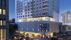 A multi-story hotel with a modern design, featuring a large entrance and several ground-level amenities. - Holiday Inn Express Houston Downtown by IHG (Houston)