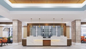 A modern reception area with a marble counter, pendant lighting, and a view of the city through a glass wall. - Holiday Inn Express Houston Downtown by IHG (Houston)