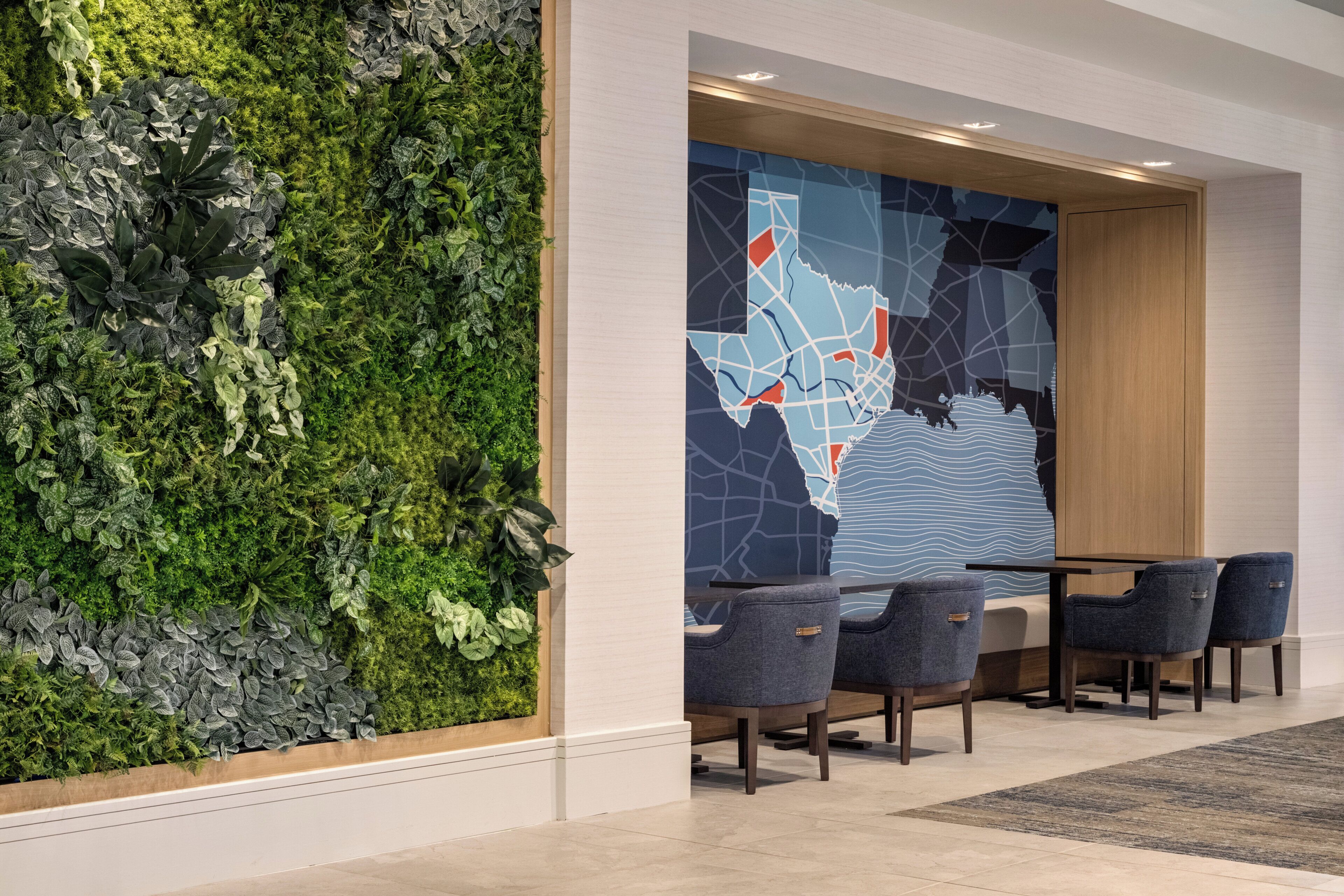 A modern interior with a green wall, a map mural, and a seating area with chairs.