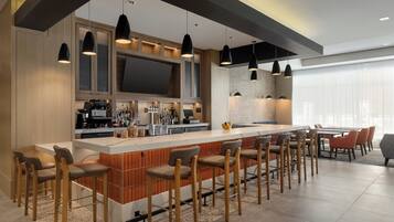 A modern kitchen with a central island, bar stools, and pendant lighting.