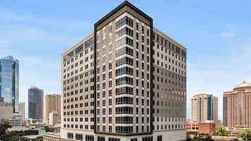 A multi-story building with a corner design, large windows, and a flat roof.
