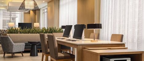 Un moderno vestíbulo de hotel con mostrador de recepción, zona de estar y amplios ventanales.