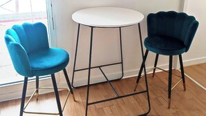 A room with a wooden floor, a white round table, and two chairs with metal frames and velvet upholstery. - Large Studio in quiet inner-city location (Dinan)