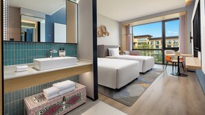 A modern hotel room with a large bed, a separate sofa, a desk, and a bathroom with a large mirror and sink. - Holiday Inn Express Nalati by IHG (Xinyuan)