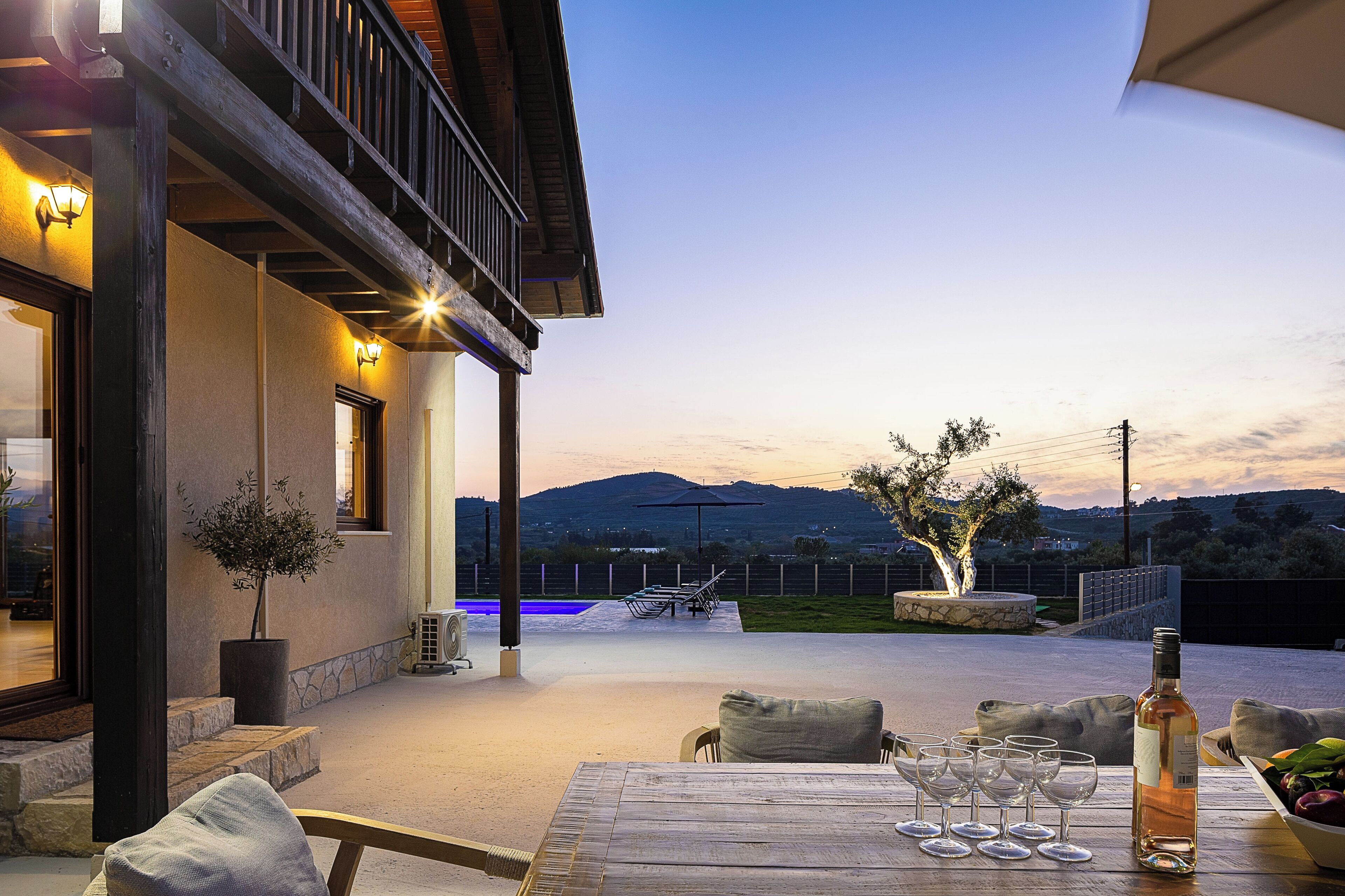 A patio with a table set for dining, outdoor seating, and a view of the landscape.