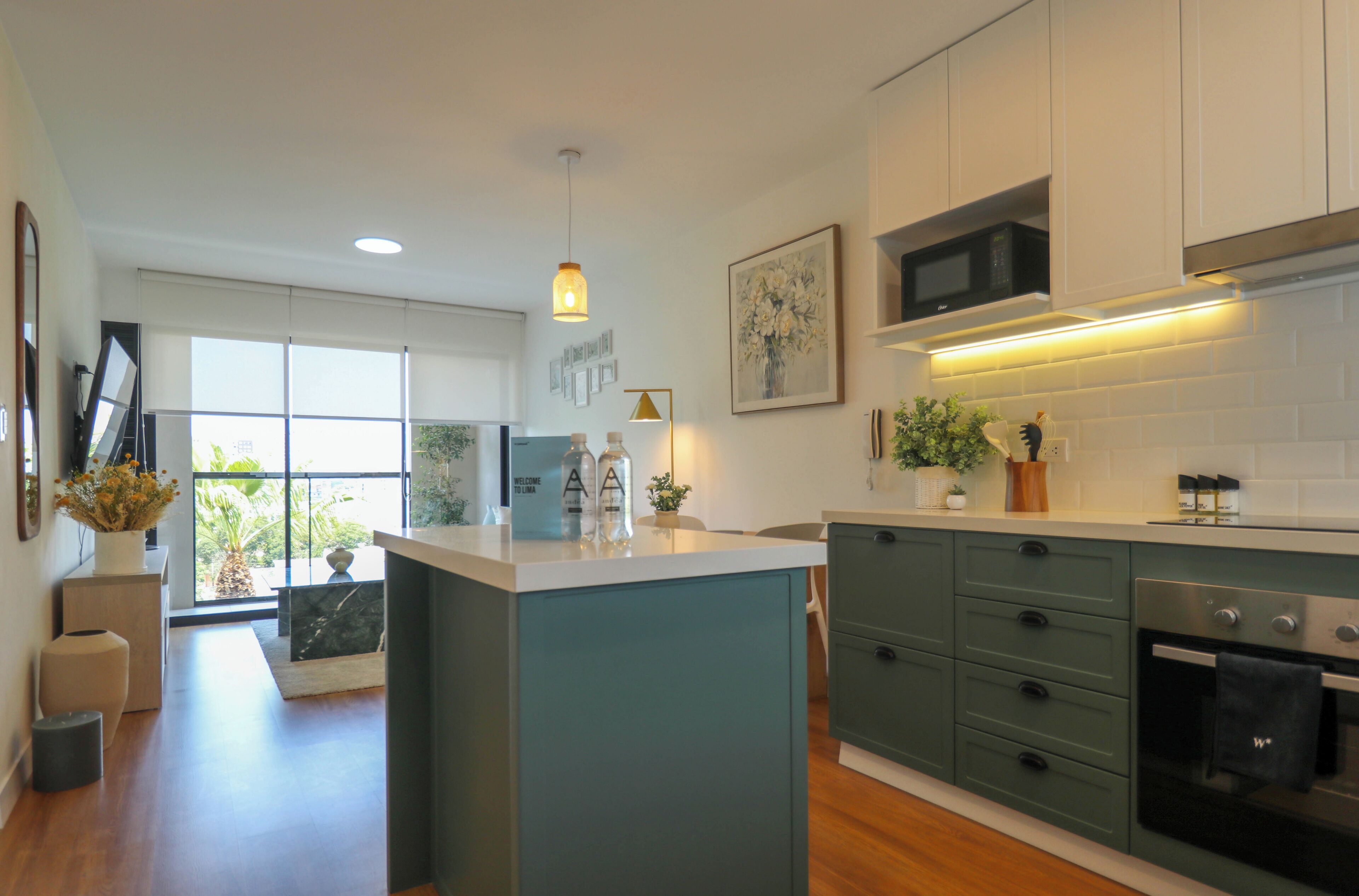A modern kitchen with a central island, built-in appliances, and a view to the outdoors.