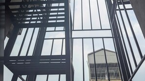Interior d'un edifici alt amb una estructura metàl·lica complexa i grans finestrals.