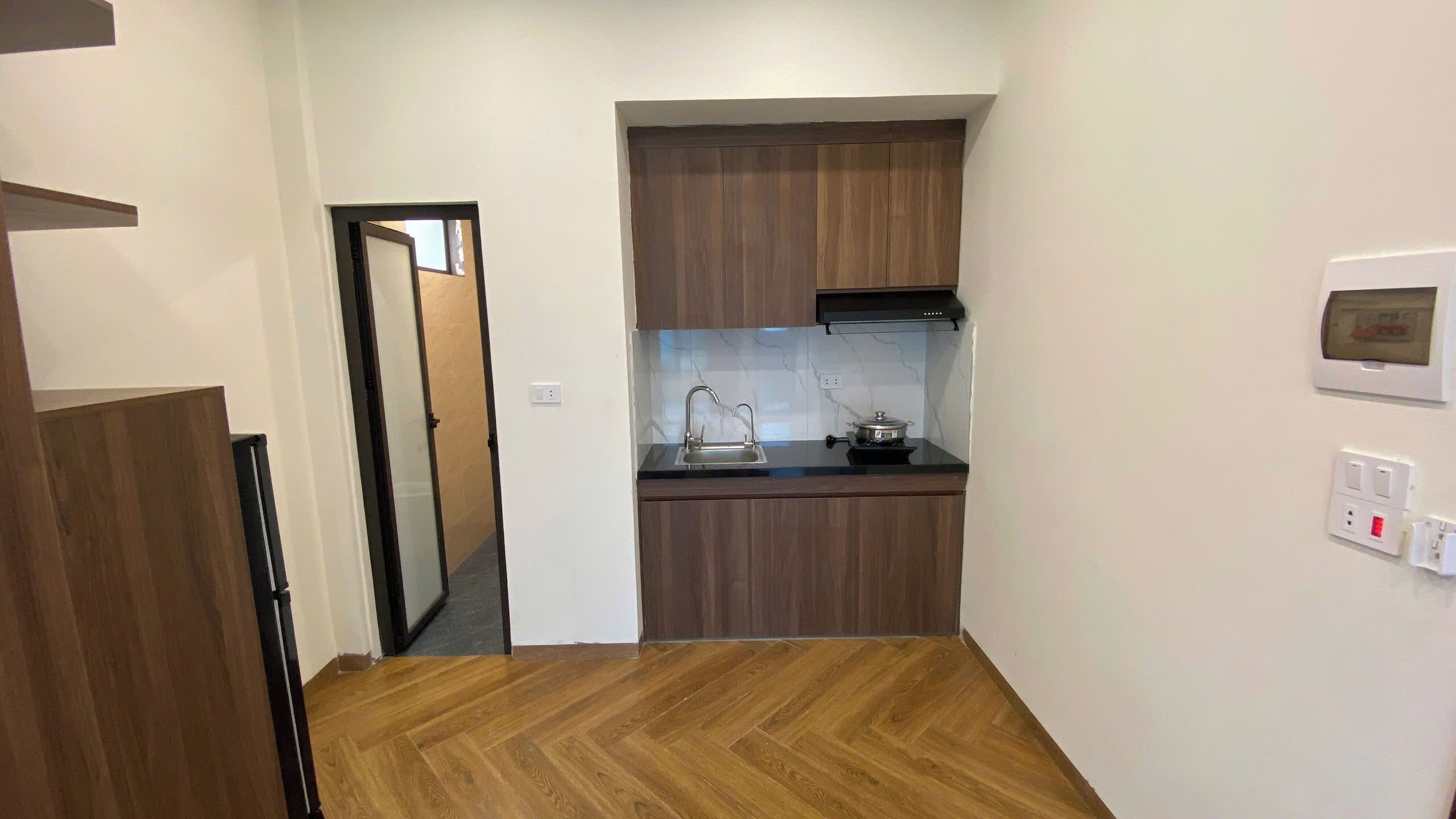 A compact kitchen with a sink, stove, and wooden cabinets.