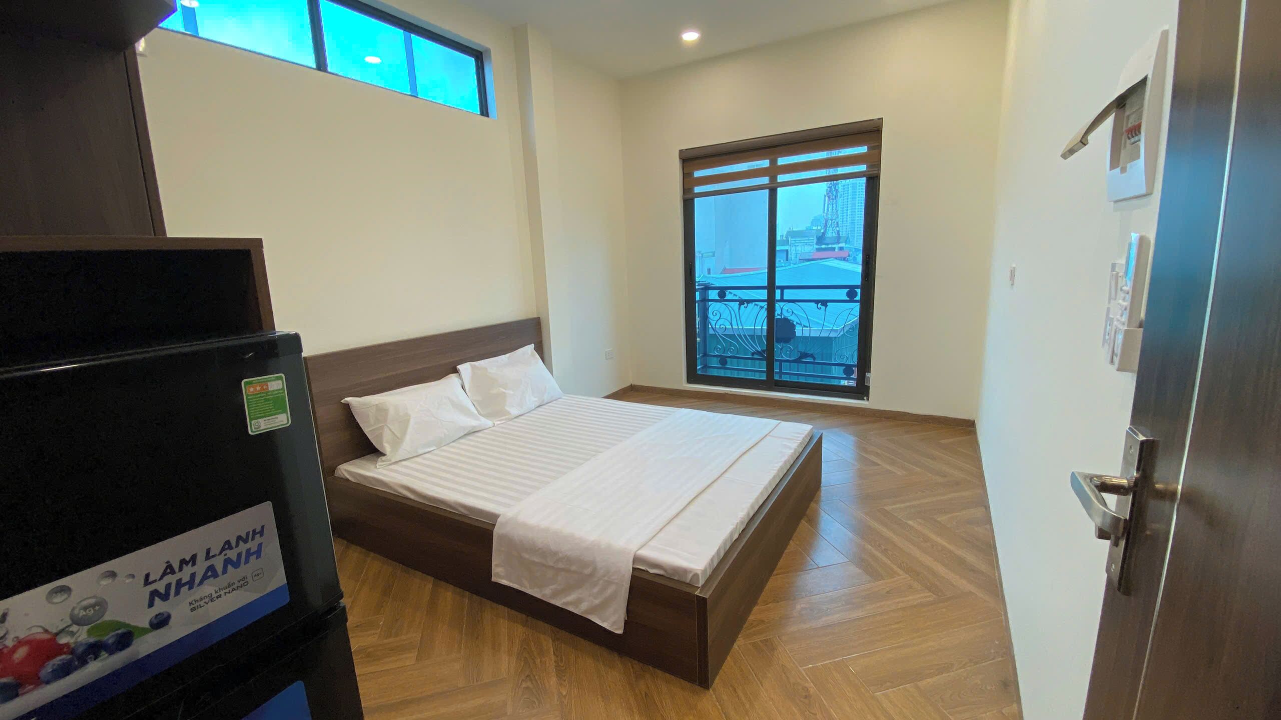 Un dormitorio con cama, ventana y puerta.