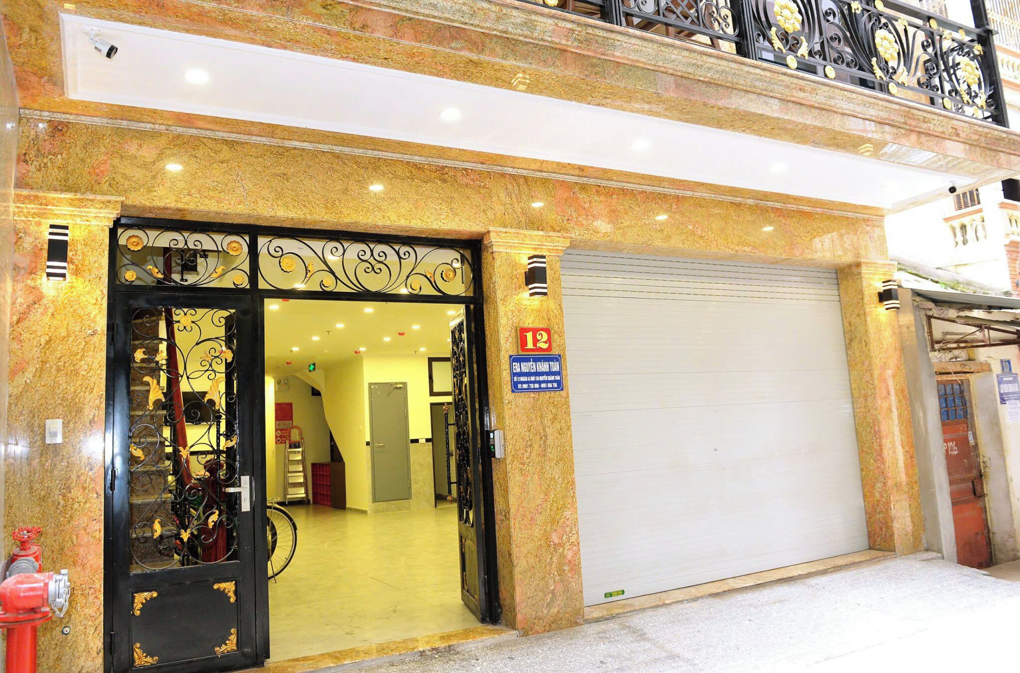 L’entrée d’un hôtel, avec une grille en métal décorative, une porte de garage fermée et une borne d’incendie sur le trottoir.