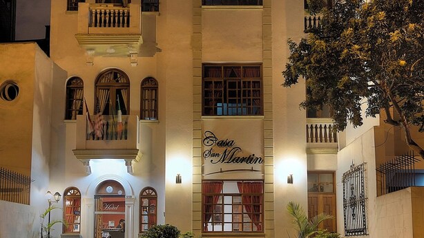 A hotel facade with multiple balconies, a central entrance with steps, and a sign reading "Casa Martin."