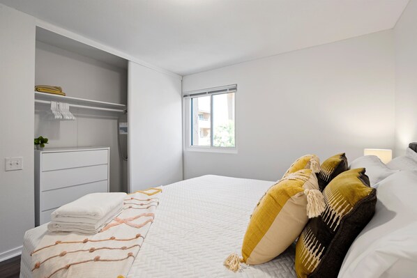 A bedroom with a bed, a window, and a closet.