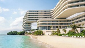 A modern hotel with multiple balconies, a beachside location, and clear turquoise waters. - SHA Mexico - Lifestyle Optimization Program - Personalized Meal Plan (Cancun)