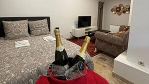 Un dormitorio moderno con una cama grande, un televisor y una alfombra roja.