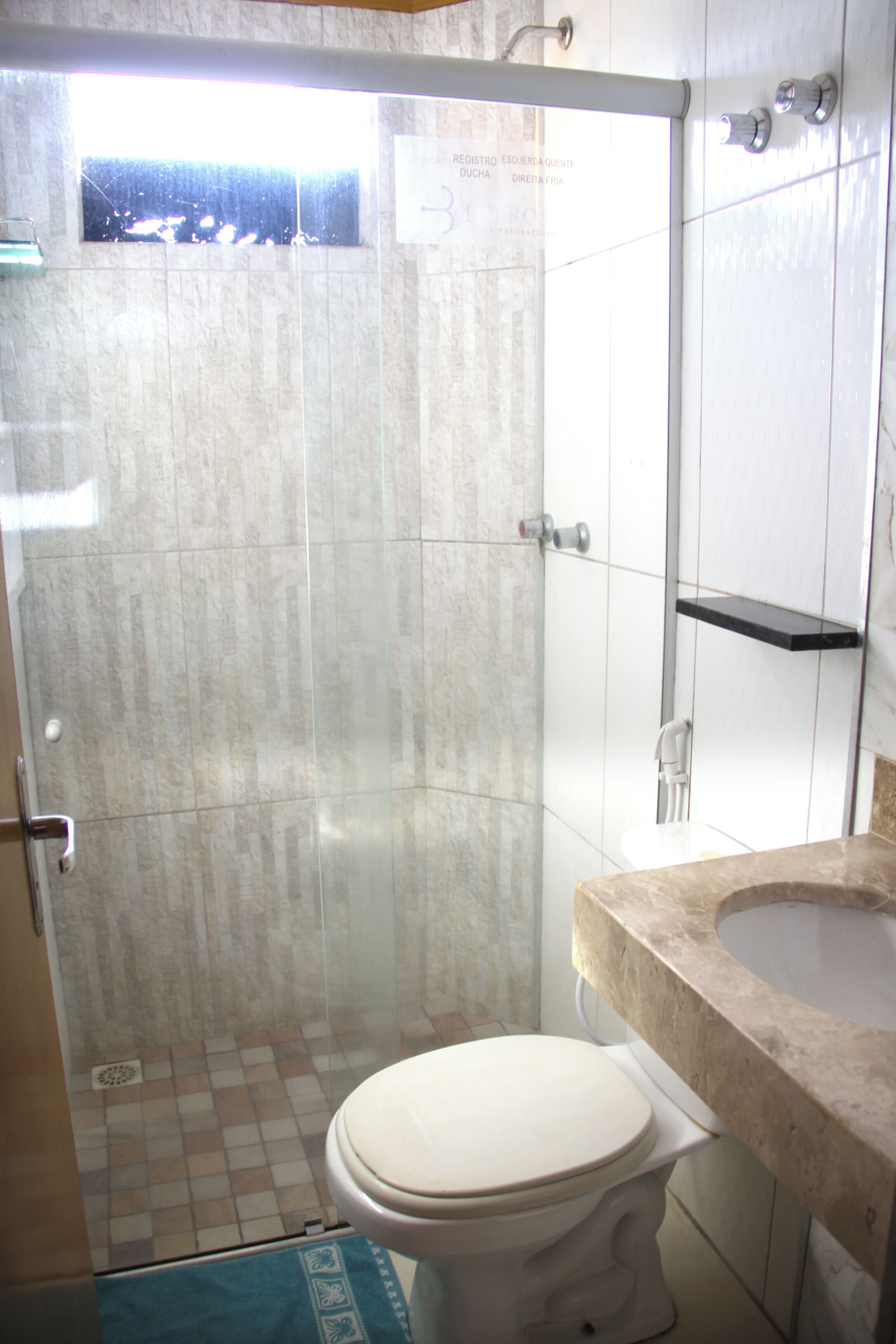 A bathroom with a shower, toilet, and sink.