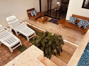 A patio area with lounge chairs, a sofa set, and a potted plant. - Duplex House Pool and Beaches Nearby (Bávaro)