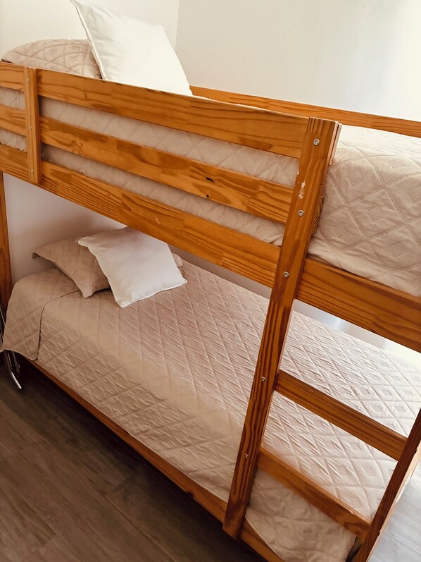 Un lit superposé avec une structure en bois et deux niveaux de couchage.