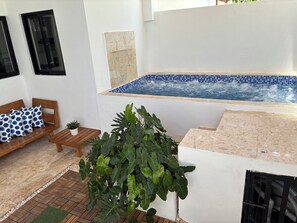 A pool area with a tiled edge, a wooden bench, and a potted plant. - Duplex House Pool and Beaches Nearby (Bávaro)