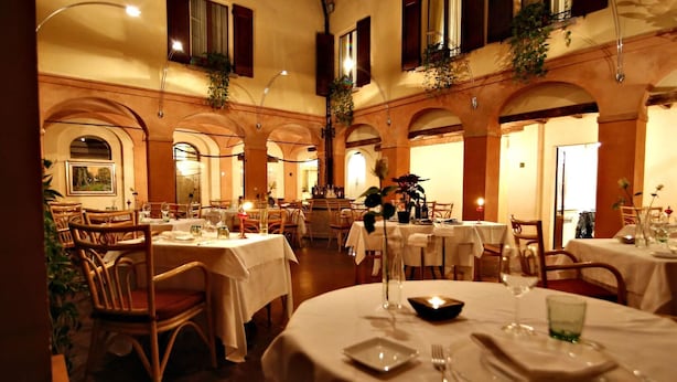 A restaurant with round tables, white tablecloths, and wooden chairs. - La Locanda Di Bagnara (Bagnara di Romagna)