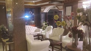 A spacious lobby with a white sofa set, a round coffee table, and a decorative vase with flowers. - Dreamers Cairo Hotel (Giza)