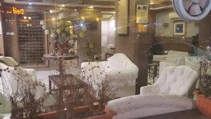 A hotel lobby with a central seating area, a reception desk, and a wall with framed pictures. - Dreamers Cairo Hotel (Giza)