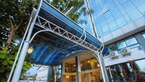 Un bâtiment moderne doté d’une façade en verre, d’un porche et d ’une structure métallique au-dessus de l’entrée.