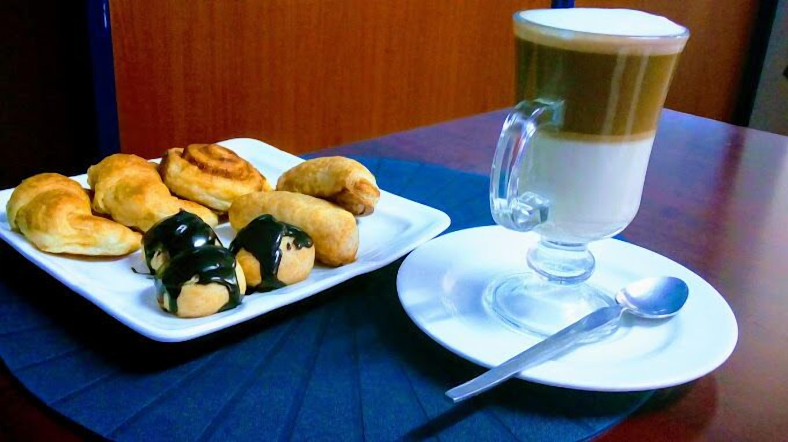 A plate of pastries and a cup of coffee on a table.