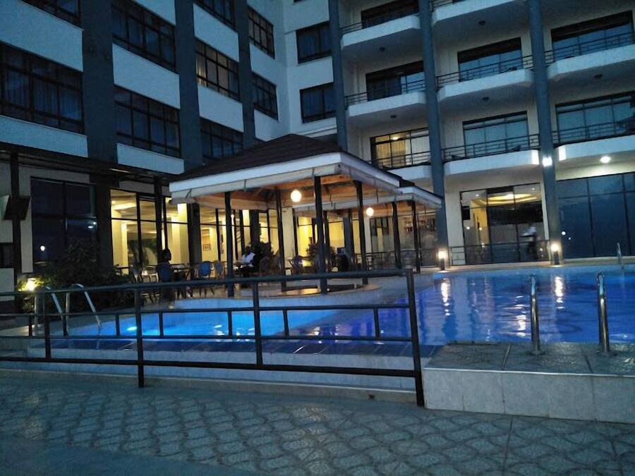 A modern building with a swimming pool and outdoor seating area.