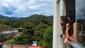A view from a window overlooking a mountainous landscape with greenery and a few buildings in the distance. - HOTEL DESTINO AVENTURA PERU (Chanchamayo)