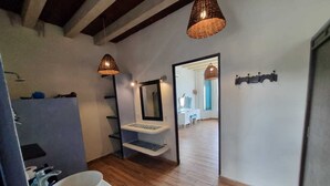 A modern bathroom with a large mirror, a white sink, wooden flooring, and two hanging pendant lights. - Casa Columpios playa alberca terraza familiar (Progreso)