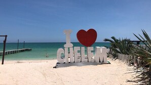 A beach with a sign that reads "I love CHELEM" and a wooden pier extending into the water. - Casa Columpios playa alberca terraza familiar (Progreso)