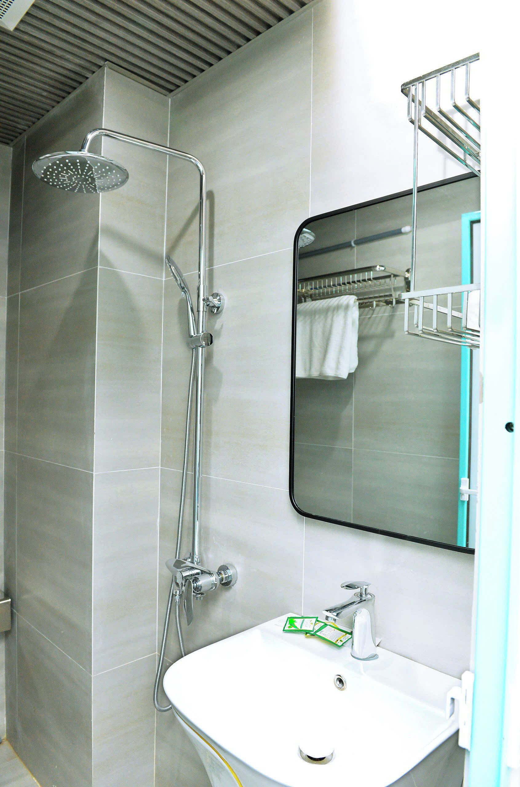 A bathroom with a shower, sink, and mirror.