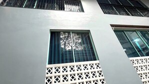 A multi-story building with balconies, large windows, and a flat roof. - Era Apartment Cat Linh (Hanoi)