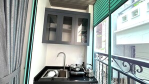A compact kitchen with a sink, stove, and cabinets. - Era Apartment Cat Linh (Hanoi)