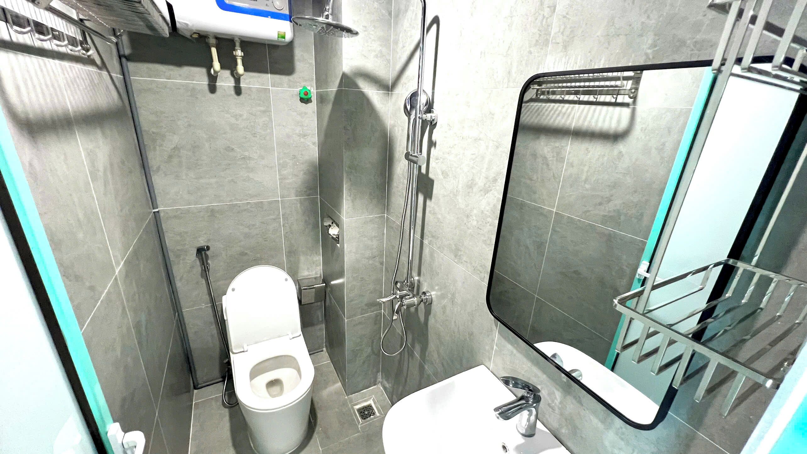 A modern bathroom with a toilet, sink, and shower.