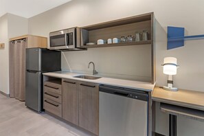 A modern kitchen with a built-in microwave, stainless steel appliances, a sink, and a dishwasher. - Home2 Suites By Hilton Calera (Calera)