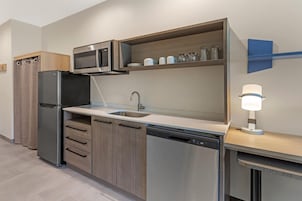 A modern kitchen with a built-in microwave, stainless steel appliances, a sink, and a dishwasher.