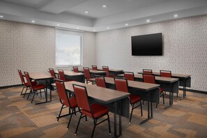 A conference room with multiple tables and chairs, a large window, and a flat-screen TV mounted on the wall. - Home2 Suites By Hilton El Paso East Loop 375 (El Paso)