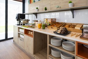Una cocina moderna con cafetera, productos para el desayuno y un cartel que dice 'Delight in the day'.