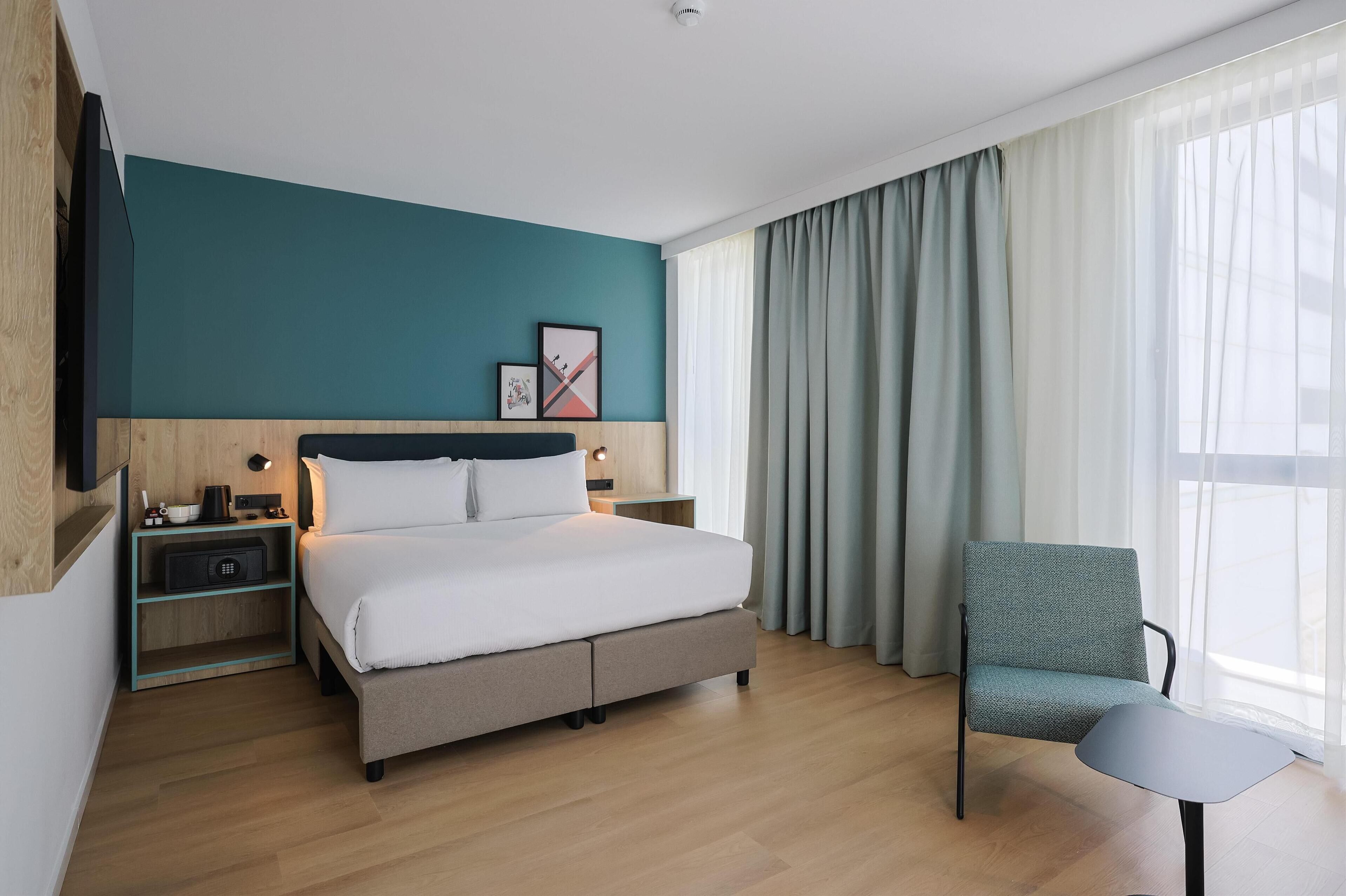 Habitación, 1 cama de matrimonio grande | Caja fuerte, escritorio, cortinas opacas y tabla de planchar con plancha