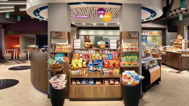 A 24/7 market with a variety of snacks and beverages, a coffee station, and a breakfast area. - Tru By Hilton Joliet Plainfield (Joliet)