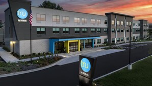 A modern hotel with a flat roof, large windows, and a blue entrance. - Tru By Hilton Joliet Plainfield (Joliet)