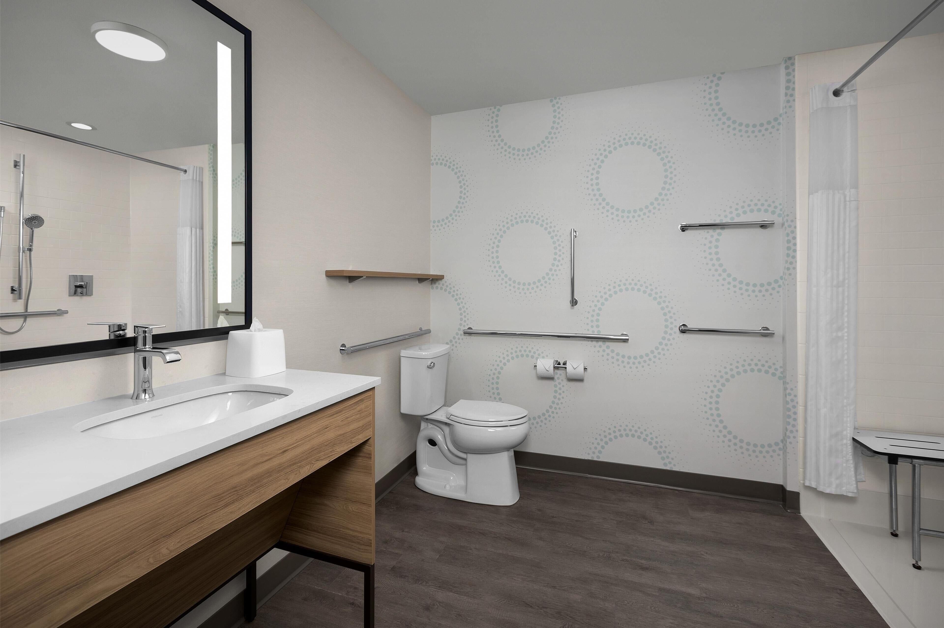 A modern bathroom with a sink, toilet, and shower.