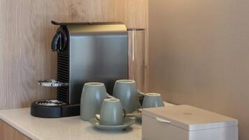 A coffee maker with four cups on a countertop.