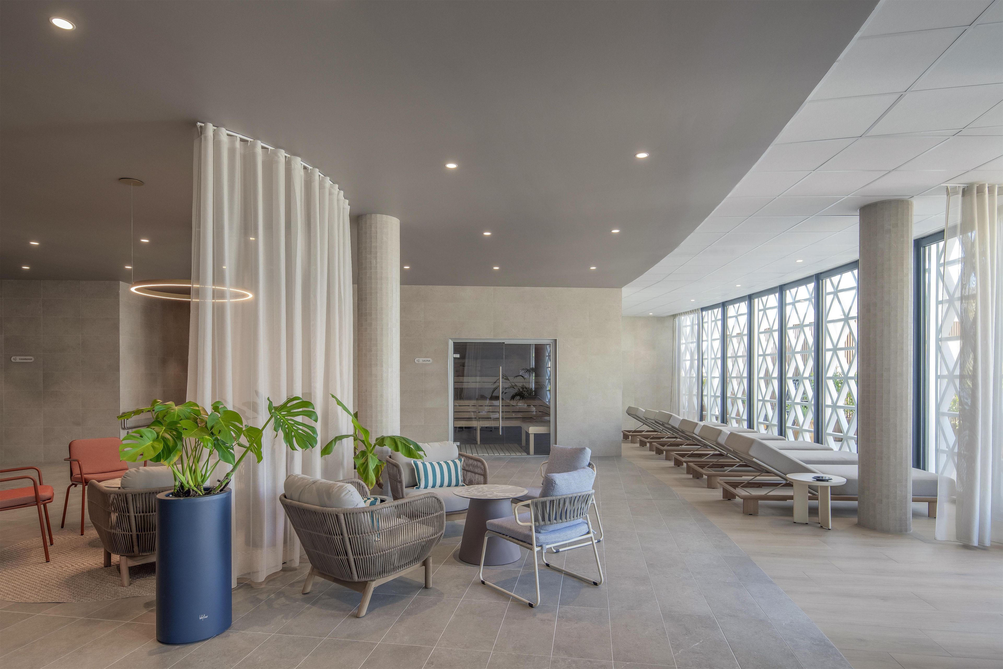 Un hall d’entrée spacieux, doté d’espaces de détente, de grandes fenêtres et d’un design moderne.